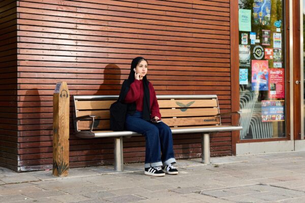 a girl sat on a bench outside