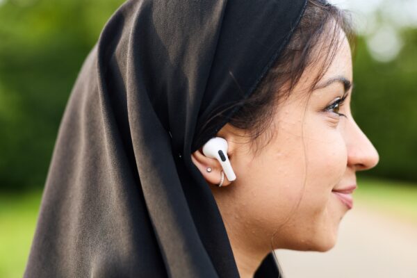 close up of a young girls earphone in, she's smiling