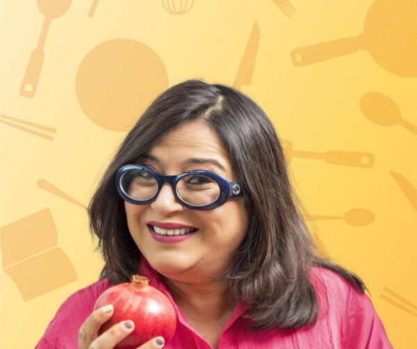 A lady smiling holding a pomegranate