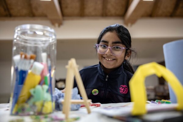 Young girl smiling across a table