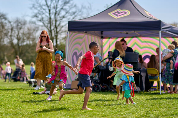 children running about outside on the grass on a sunny day