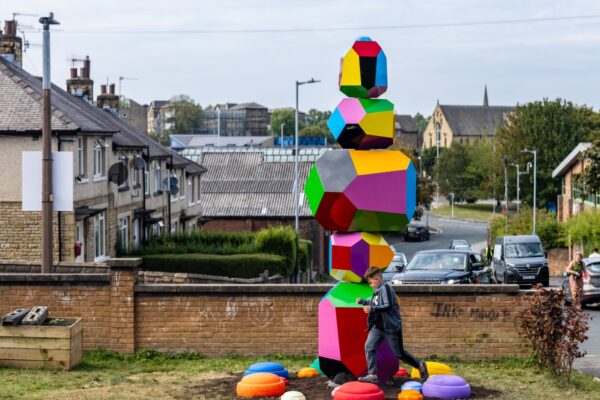 Colourful obelisk-shaped structure with child walking in front of it
