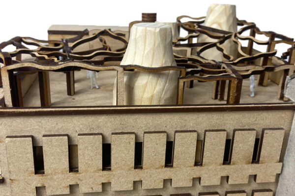 Wooden model of a building with a modernist sculpture on top.