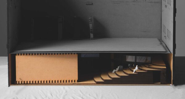 A cardboard model of a building - long and flat with a set of stairs.