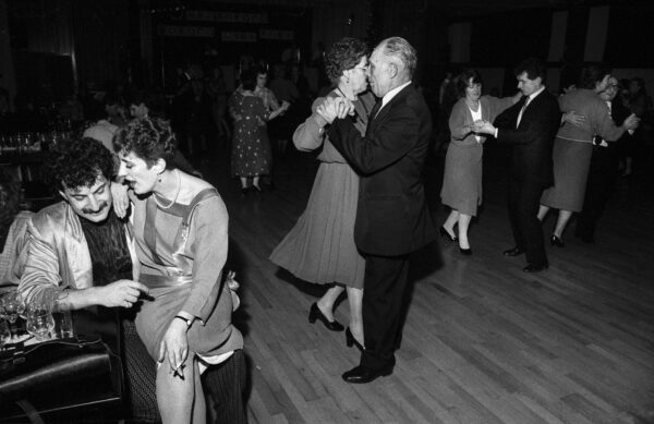 A black and white photo of couples dancing and socialising.