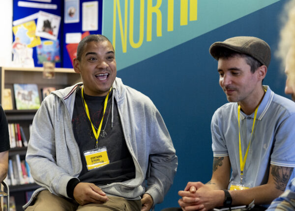 A black man smiles at the camera.