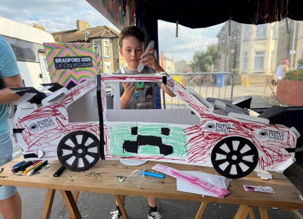 Young boy arts and crafting on a cardboard car