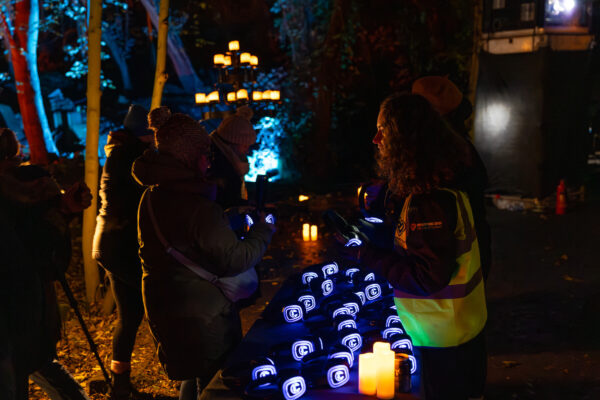 A lady giving out headphones to audience