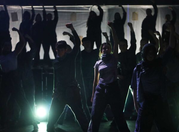 A group of dancers in silhouette.