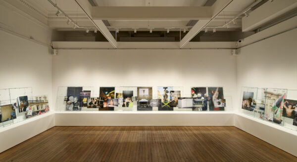 A long shelf on three sides - there are artworks along it. These are all photographs of people and places.