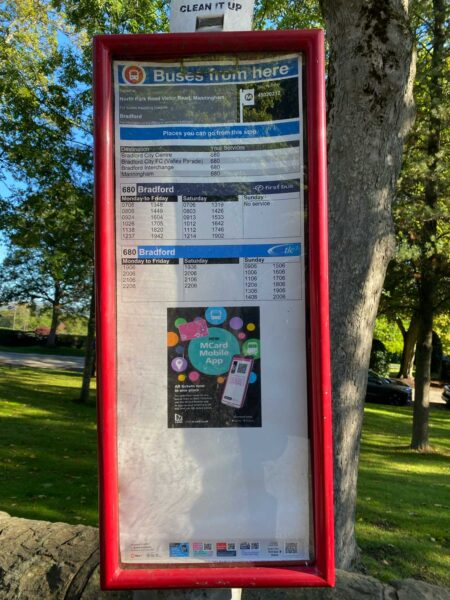 A bus stop time table with a red frame. It includes a table with bus times.