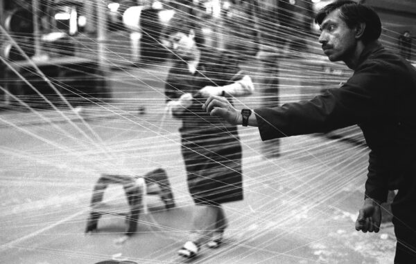 A black and white image of a woman and a man weaving fabric in a mill.