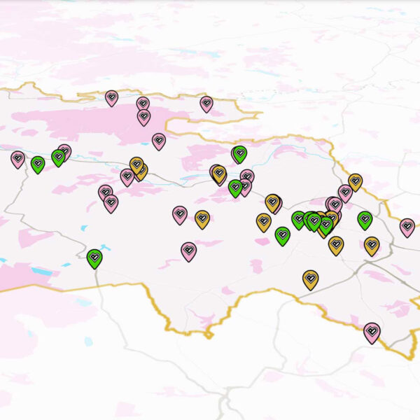 A pink and white map of Bradford District, with small colourful pins on it.
