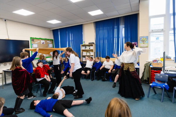 A primary school class engaging in an acting wokrshop