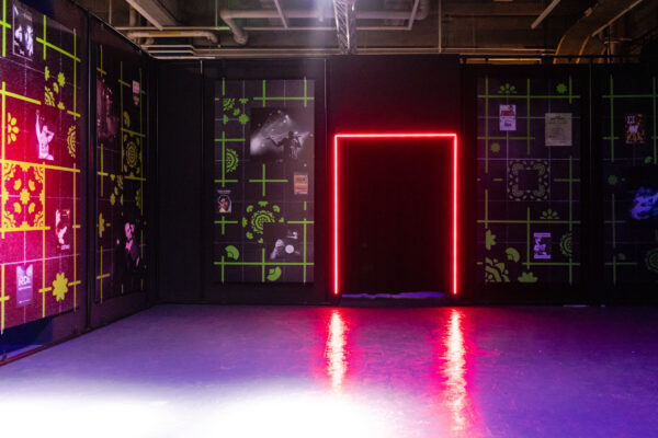 A glowing pink doorway and glowing art on the walls in the basement of Loading Bay