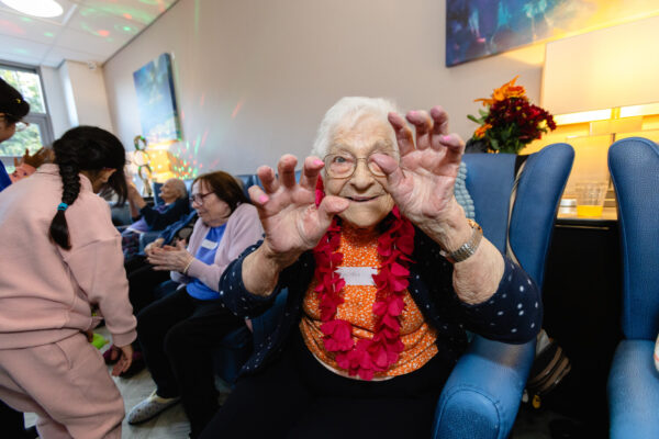 An elderly lady playing towards the camera having fun