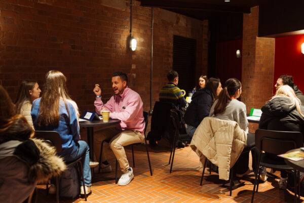 People sat down in a ha;; having converstaions