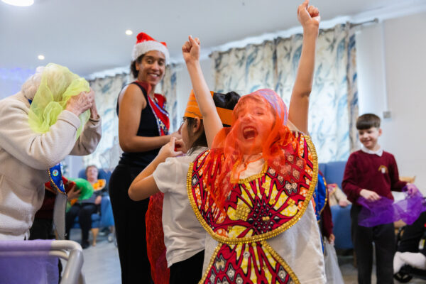 Young children with colourful mesh sheets over their heads playing