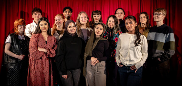 A group of young people all posing and smiling to the camera