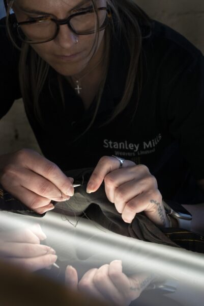 A young woman working on denim fabric.