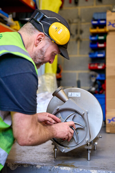A man using a metal machine in a workshop.
