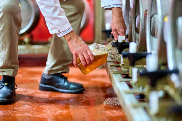 A man dispenses beer into a bottle.