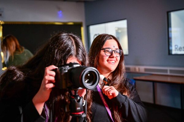 Two young people use a camera.