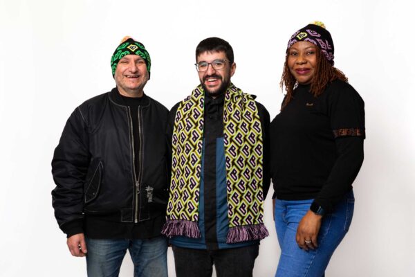 Three models wearing Bradford 2025 branded hats and scarves.
