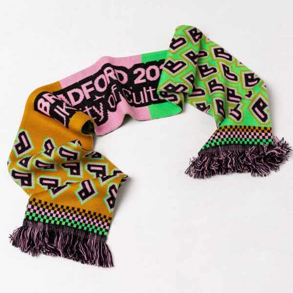 A Bradford 2025 scarf with gold, pink and green colours and the Bradford 2025 heart logo.